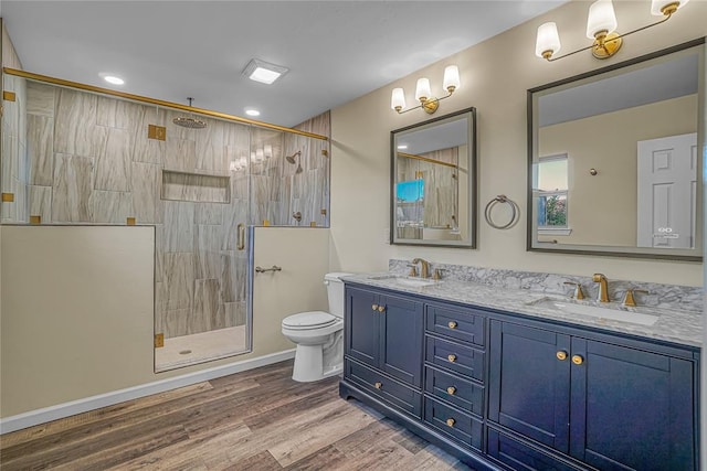 bathroom featuring vanity, wood-type flooring, an enclosed shower, and toilet