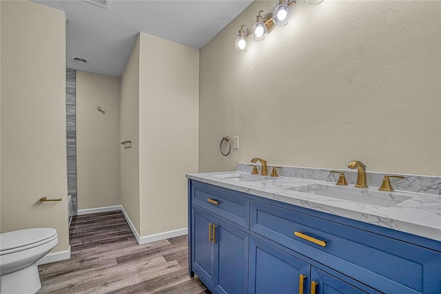 bathroom with vanity, wood-type flooring, and toilet