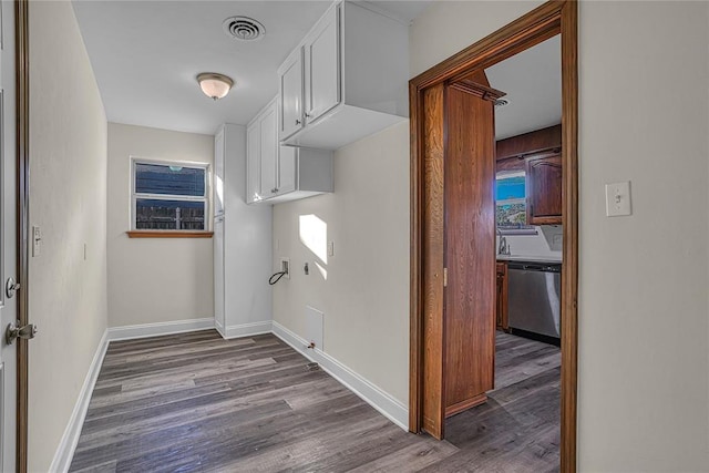 clothes washing area with dark hardwood / wood-style flooring, cabinets, plenty of natural light, and hookup for a washing machine