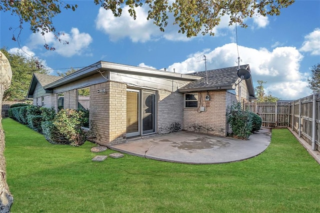 rear view of house featuring a yard and a patio area