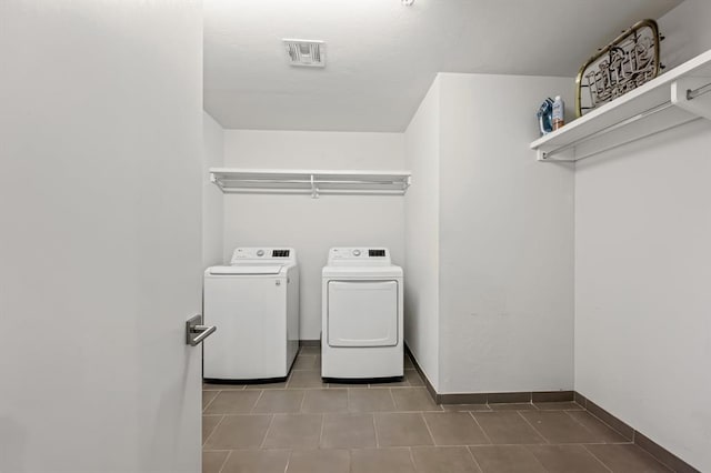 laundry area with separate washer and dryer and light tile patterned floors