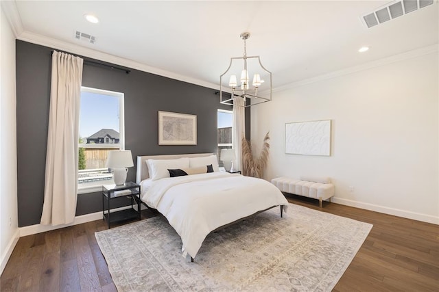 bedroom with dark hardwood / wood-style flooring, an inviting chandelier, and ornamental molding