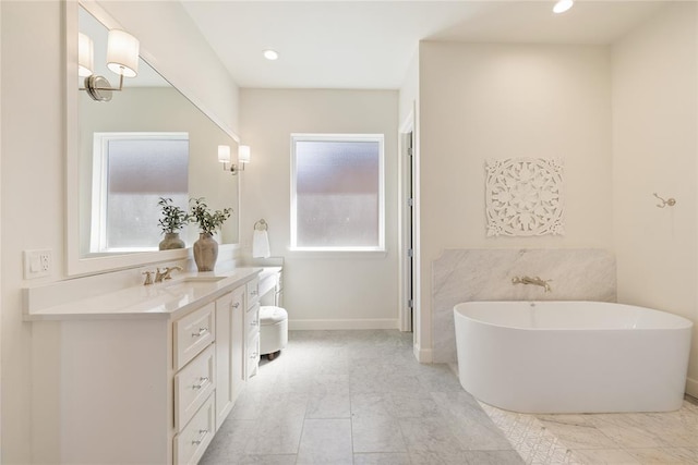 bathroom with a tub to relax in and vanity