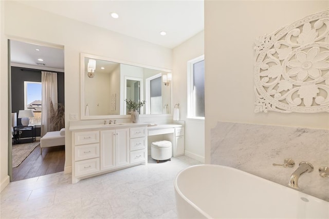 bathroom with wood-type flooring, vanity, and a tub