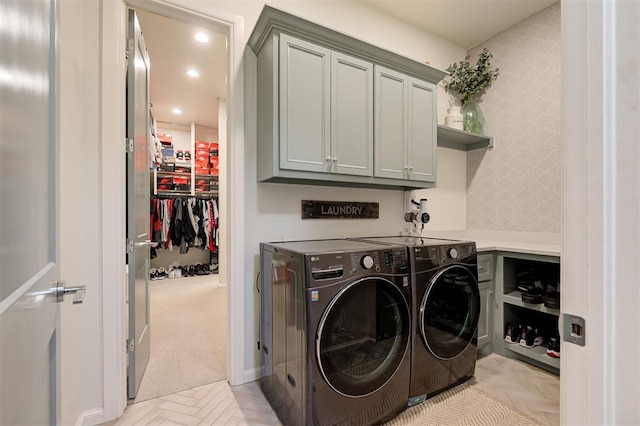 washroom featuring cabinets, washing machine and dryer, and light parquet flooring