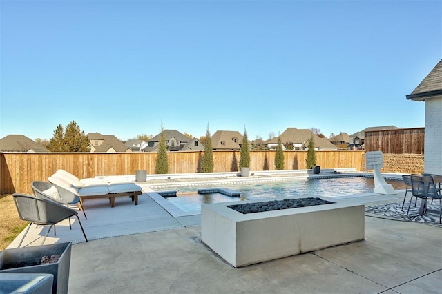 view of patio featuring a fenced in pool and a fire pit