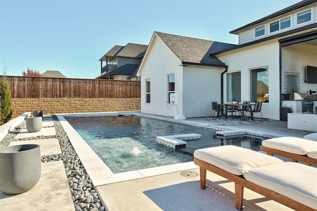 view of pool featuring a grill, pool water feature, and a patio