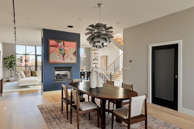 dining area featuring a multi sided fireplace and light hardwood / wood-style floors