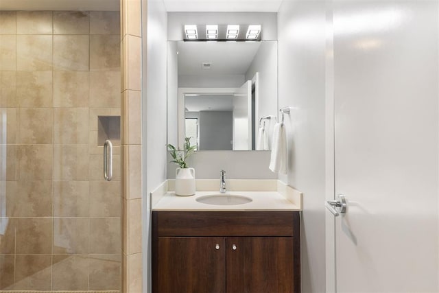 bathroom with vanity and a shower with door