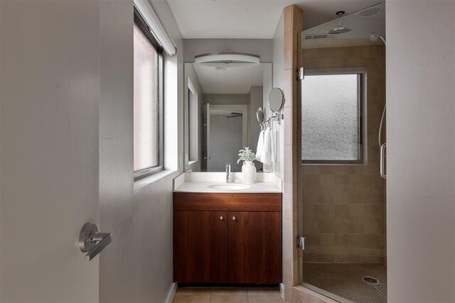 bathroom with tile patterned flooring, vanity, and a shower with shower door