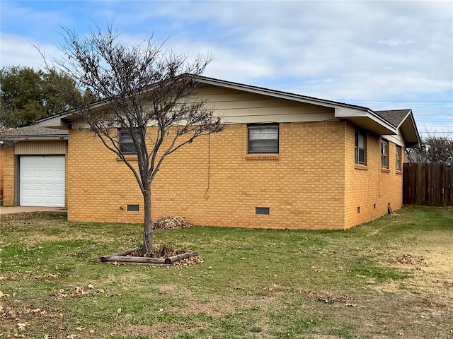 view of side of property featuring a yard and a garage