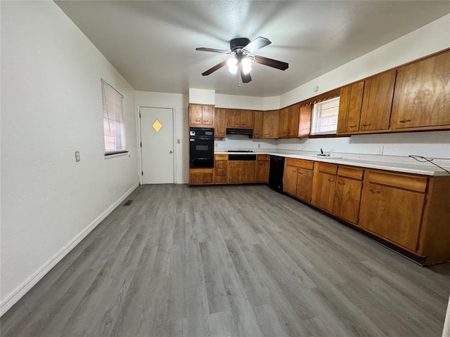 kitchen with black appliances, ceiling fan, light wood-type flooring, and sink