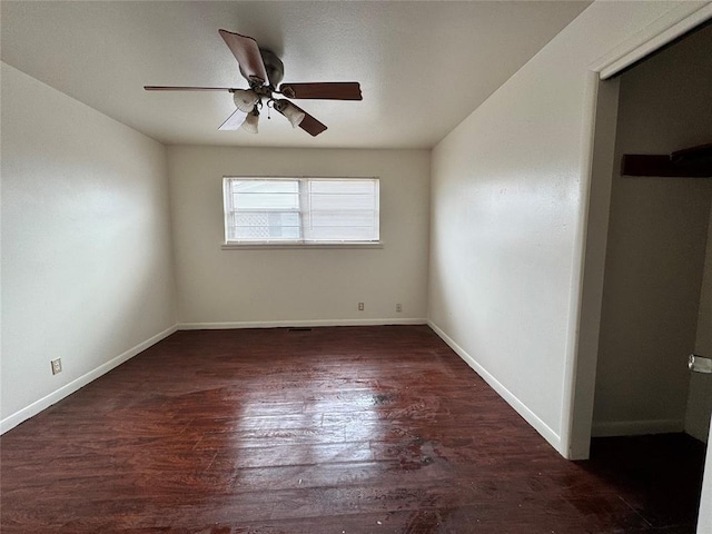 spare room with ceiling fan and dark wood-type flooring