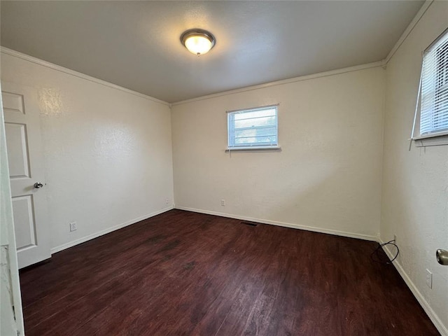 spare room featuring dark hardwood / wood-style flooring and ornamental molding