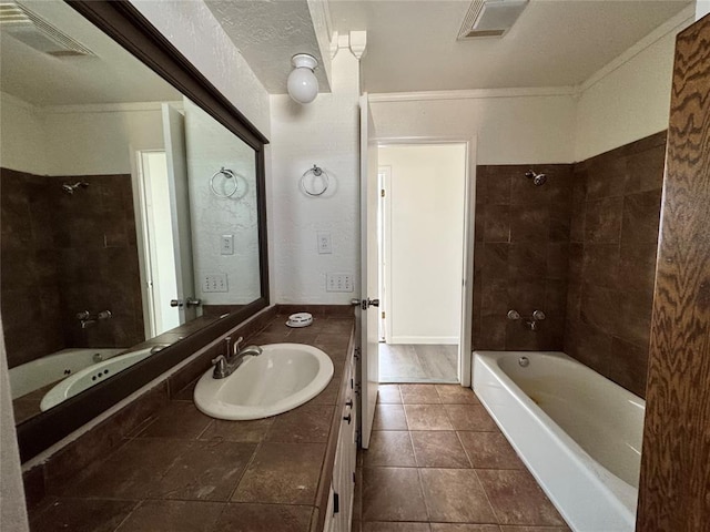 bathroom featuring tile patterned flooring, vanity, ornamental molding, and tiled shower / bath