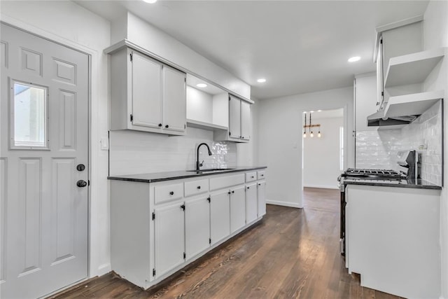 kitchen featuring white cabinetry, sink, dark wood-type flooring, range with gas cooktop, and backsplash