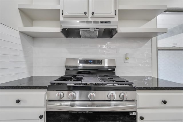 kitchen with backsplash, dark stone counters, stainless steel gas range, extractor fan, and white cabinets