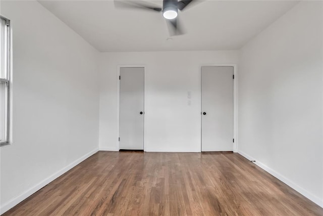 empty room with ceiling fan and hardwood / wood-style flooring