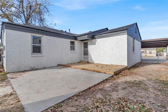 rear view of property with a patio and a carport