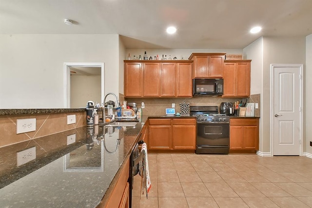 kitchen with decorative backsplash, sink, black appliances, light tile patterned floors, and dark stone countertops