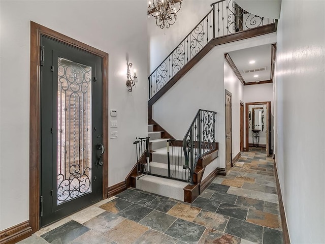 entryway featuring ornamental molding and a chandelier