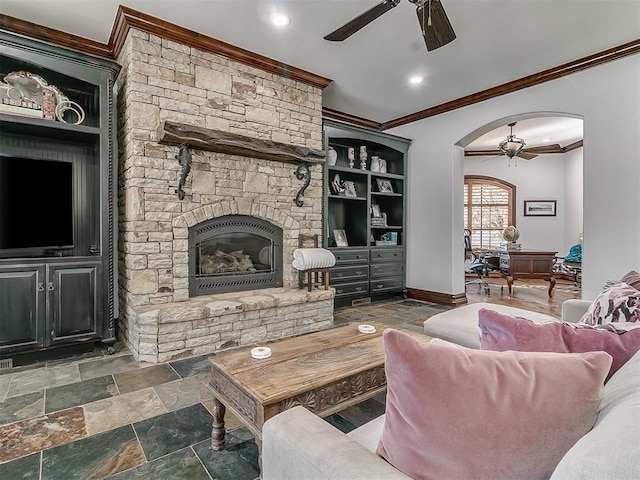 living room featuring a fireplace, ceiling fan, and crown molding