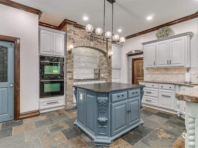 kitchen featuring decorative backsplash, white cabinets, and hanging light fixtures