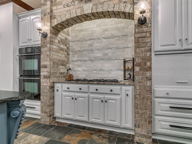 kitchen featuring gas cooktop, pendant lighting, black double oven, and white cabinetry