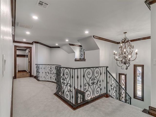 hallway featuring ornamental molding, carpet floors, and a notable chandelier