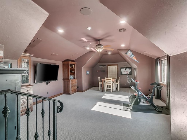 workout area featuring light carpet, vaulted ceiling, and ceiling fan