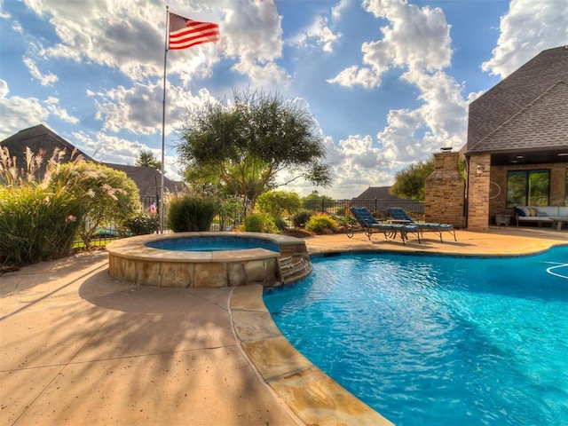 view of swimming pool featuring a patio area and an in ground hot tub