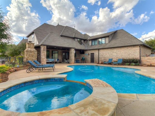 view of swimming pool featuring a patio area and an in ground hot tub