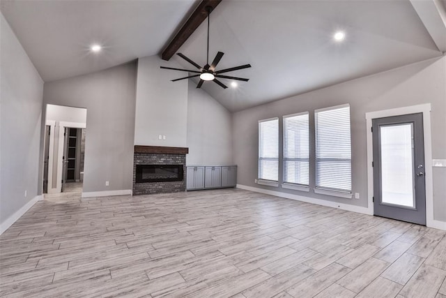 unfurnished living room featuring high vaulted ceiling, a brick fireplace, light hardwood / wood-style flooring, ceiling fan, and beam ceiling