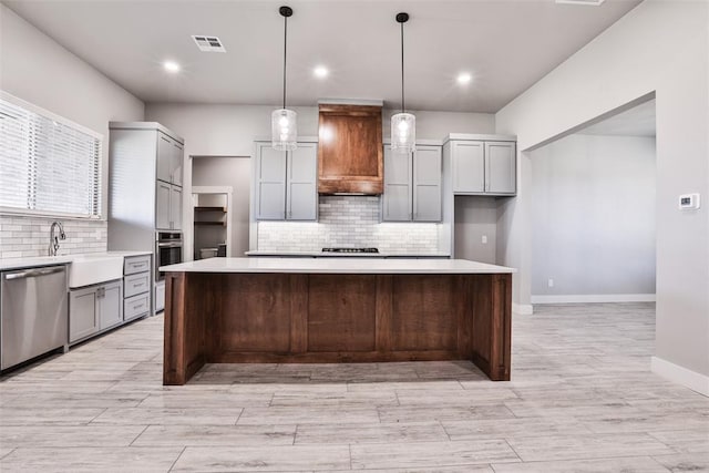 kitchen featuring gray cabinets, a spacious island, decorative light fixtures, and appliances with stainless steel finishes