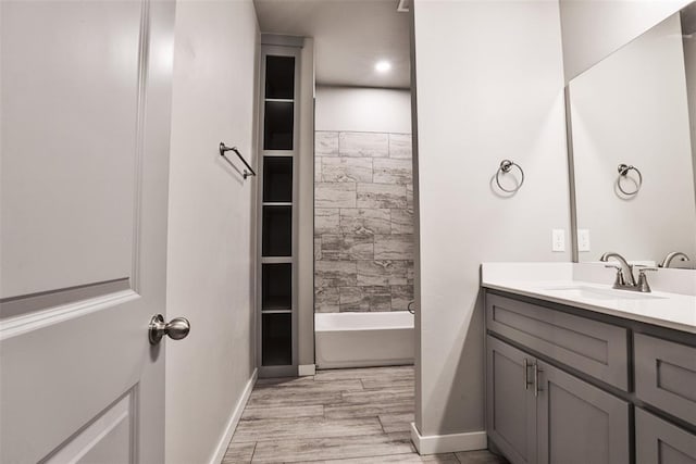 bathroom featuring hardwood / wood-style floors, vanity, and shower / bath combination