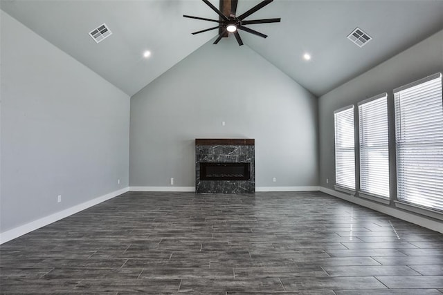 unfurnished living room with ceiling fan, dark hardwood / wood-style flooring, a high end fireplace, and high vaulted ceiling