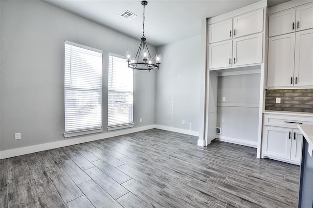 unfurnished dining area featuring a notable chandelier and light hardwood / wood-style flooring