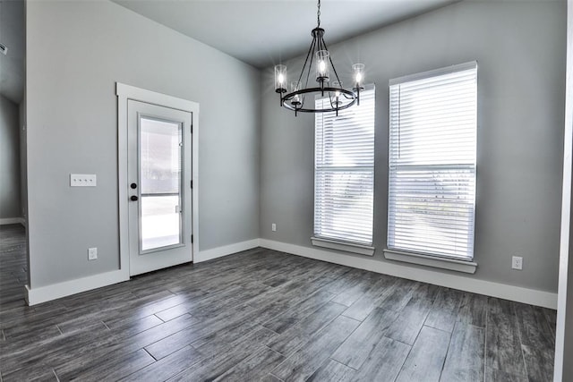 unfurnished dining area featuring dark hardwood / wood-style flooring and an inviting chandelier