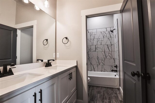 full bathroom featuring tiled shower / bath, toilet, vanity, and hardwood / wood-style flooring