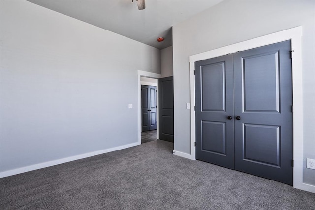 unfurnished bedroom featuring ceiling fan, a closet, and dark carpet