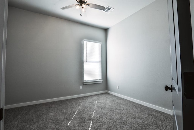 spare room featuring dark colored carpet and ceiling fan