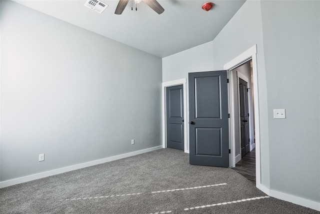 unfurnished bedroom with ceiling fan and dark carpet