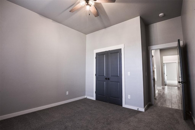 unfurnished bedroom featuring dark colored carpet and ceiling fan