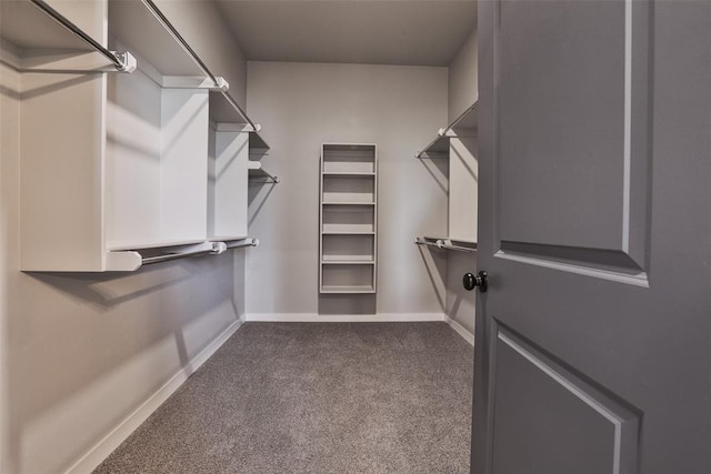 walk in closet featuring dark carpet