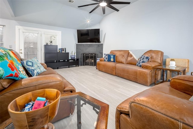 living room featuring ceiling fan and lofted ceiling