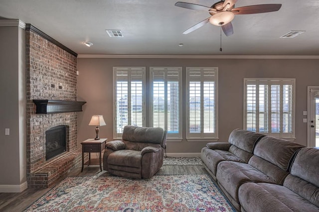 living room featuring ceiling fan, hardwood / wood-style floors, a healthy amount of sunlight, and a brick fireplace