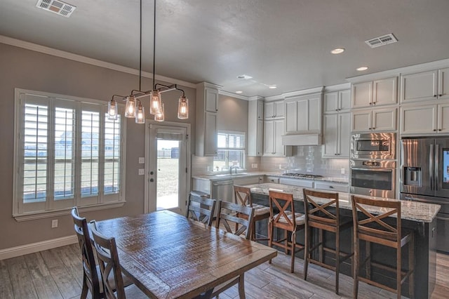31814 Landrun Ave, Norman, OK 73072 - dining area featuring ornamental molding, light wood-style flooring, and recessed lighting