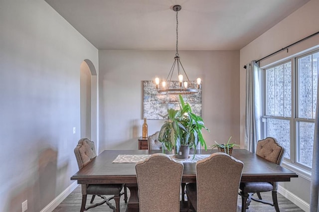 dining space with dark hardwood / wood-style floors and a chandelier