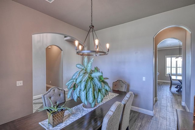 31814 Landrun Ave, Norman, OK 73072 - dining area featuring arched walkways, a chandelier, and wood finished floors