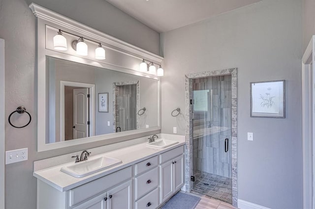 bathroom featuring a shower with door and vanity